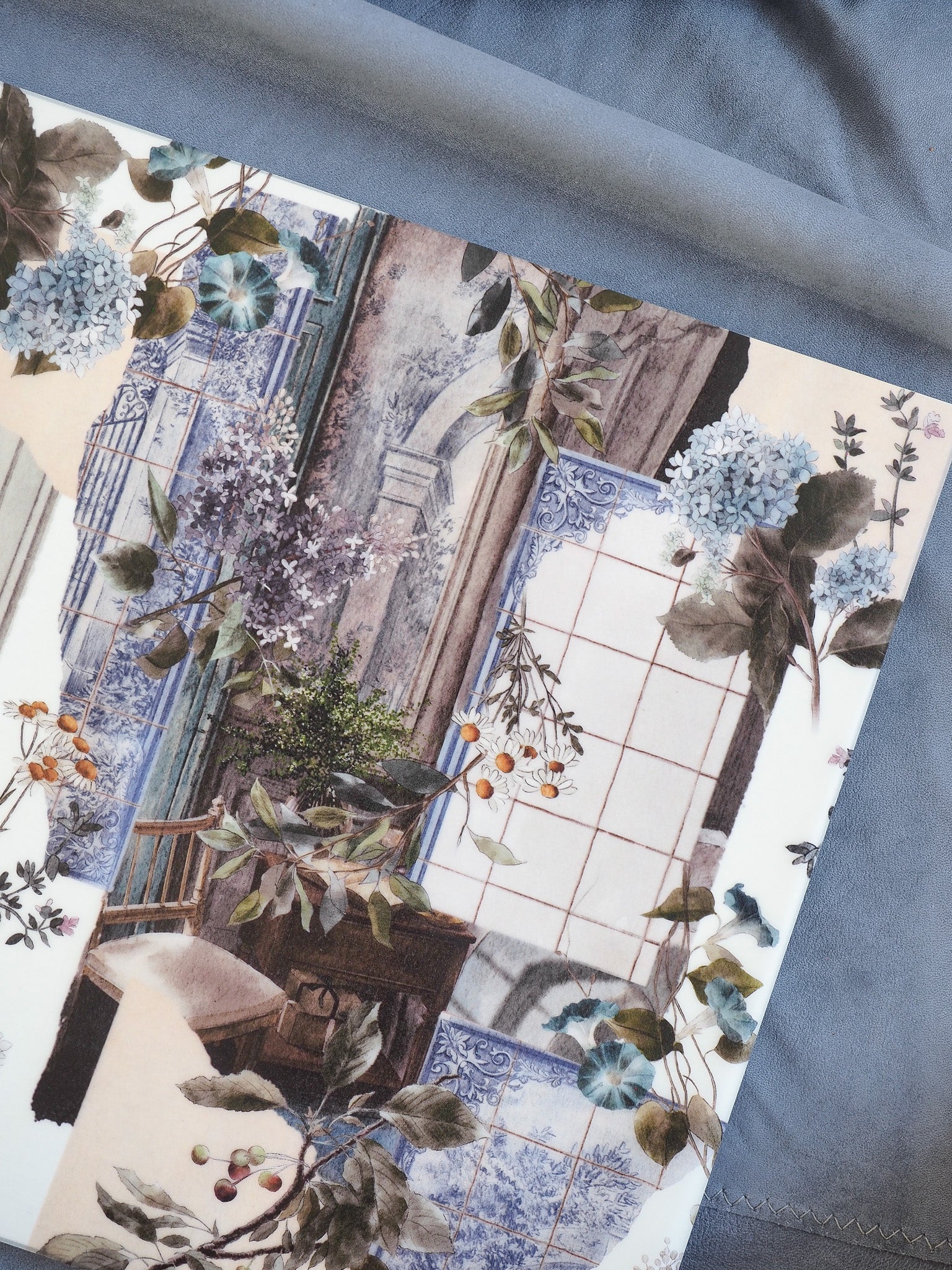 Elegant botanical and architectural illustration featuring draped greenery, eucalyptus, berries, and intricate blue tiled patterns.