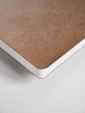 Natural, textured tan B5 grid notebook featuring a rustic kraft paper cover and crisp white binding edges.