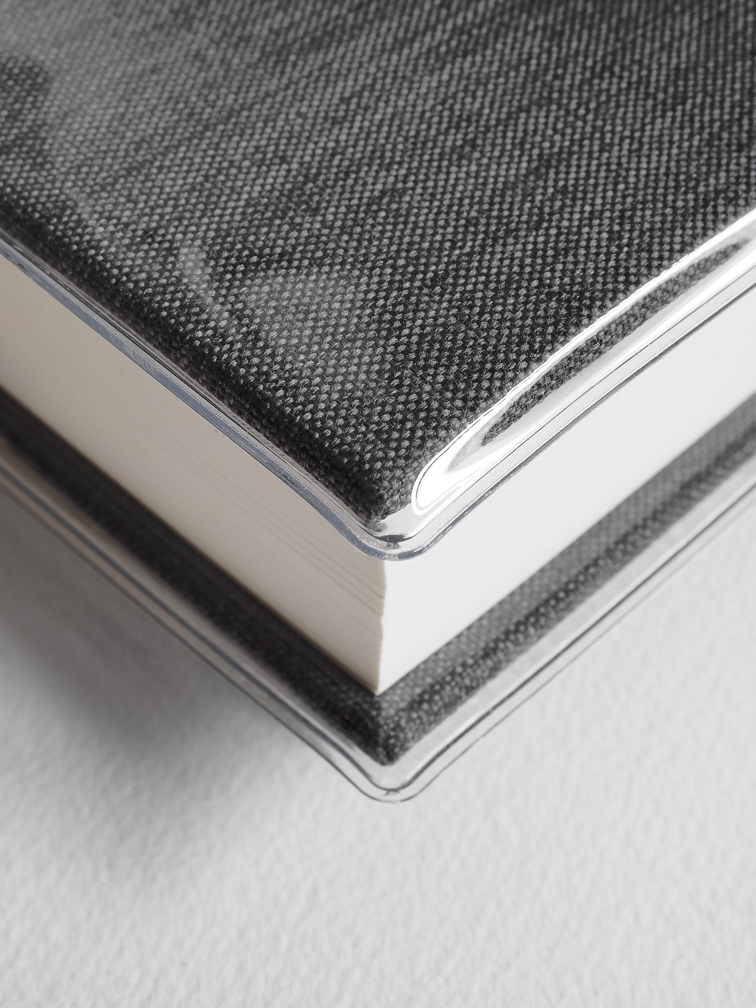 Textured charcoal gray notebook bound with a clear edge and featuring a sophisticated woven crosshatch pattern.