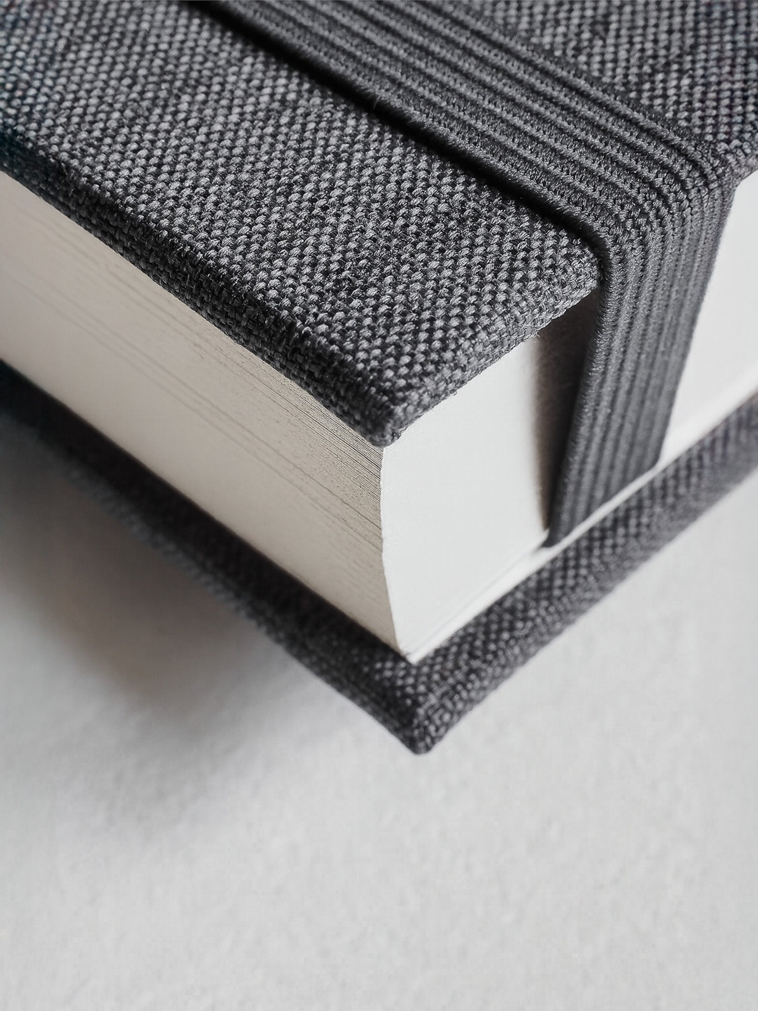 Elegant stack of two B6 hardcover diaries featuring textured dark gray woven fabric covers for organized, five-year undated planning.