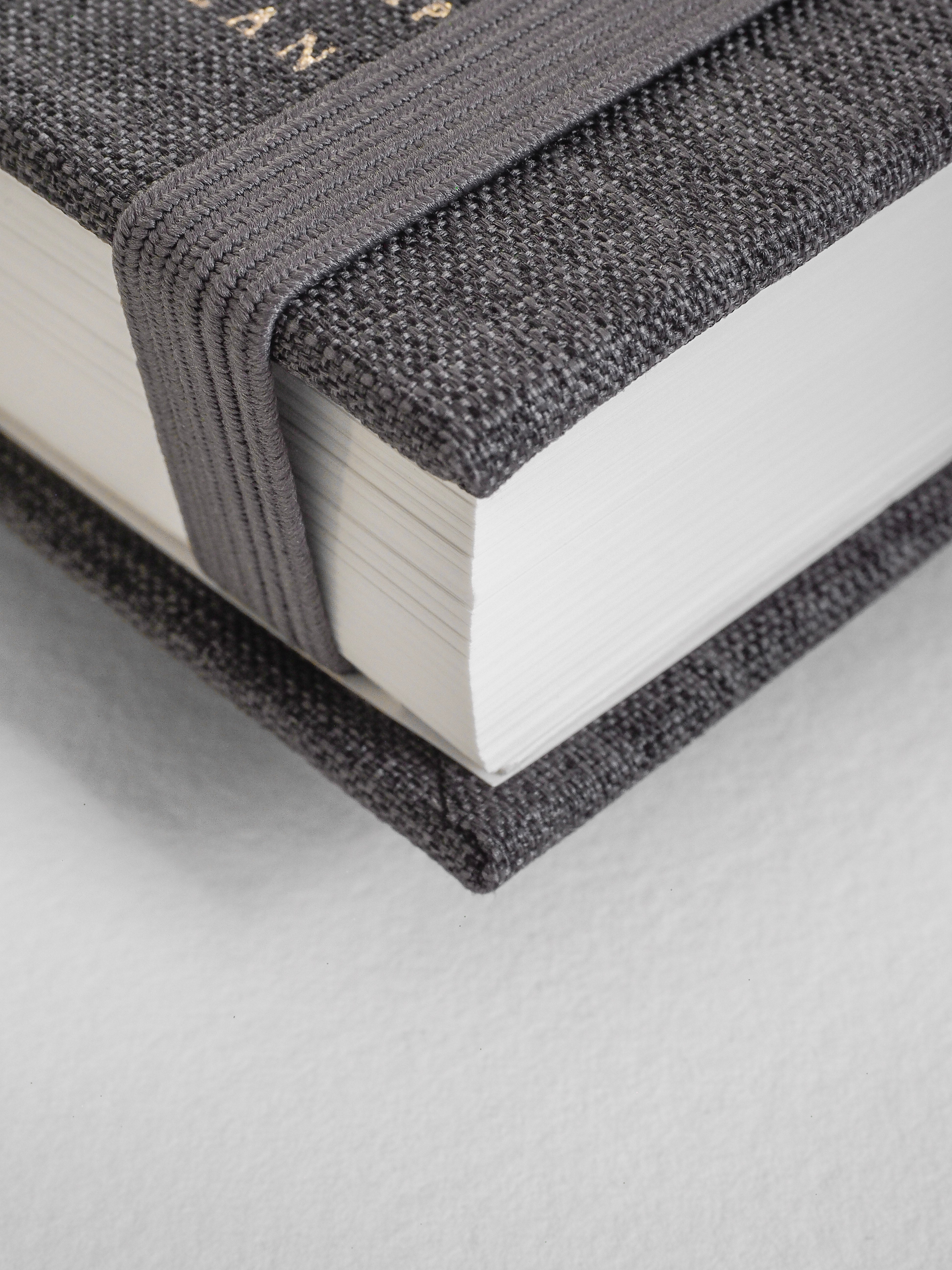 Sturdy academic planner bound in textured charcoal grey fabric, designed for comprehensive yearly planning and organization.