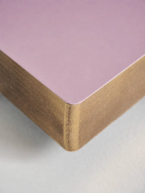 Close-up of a square product corner showing a matte light purple top surface and a natural wood grain side edge on a white background.
#Color_Fairyfloss