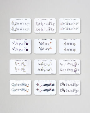 all 12 months of our Month Sticker from 2023 in the Print format. All 12 stickers are laid out in a grid format