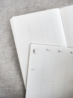 Detailed white planner pages featuring an organized grid layout with specific sections for customizable weekly and daily scheduling.
