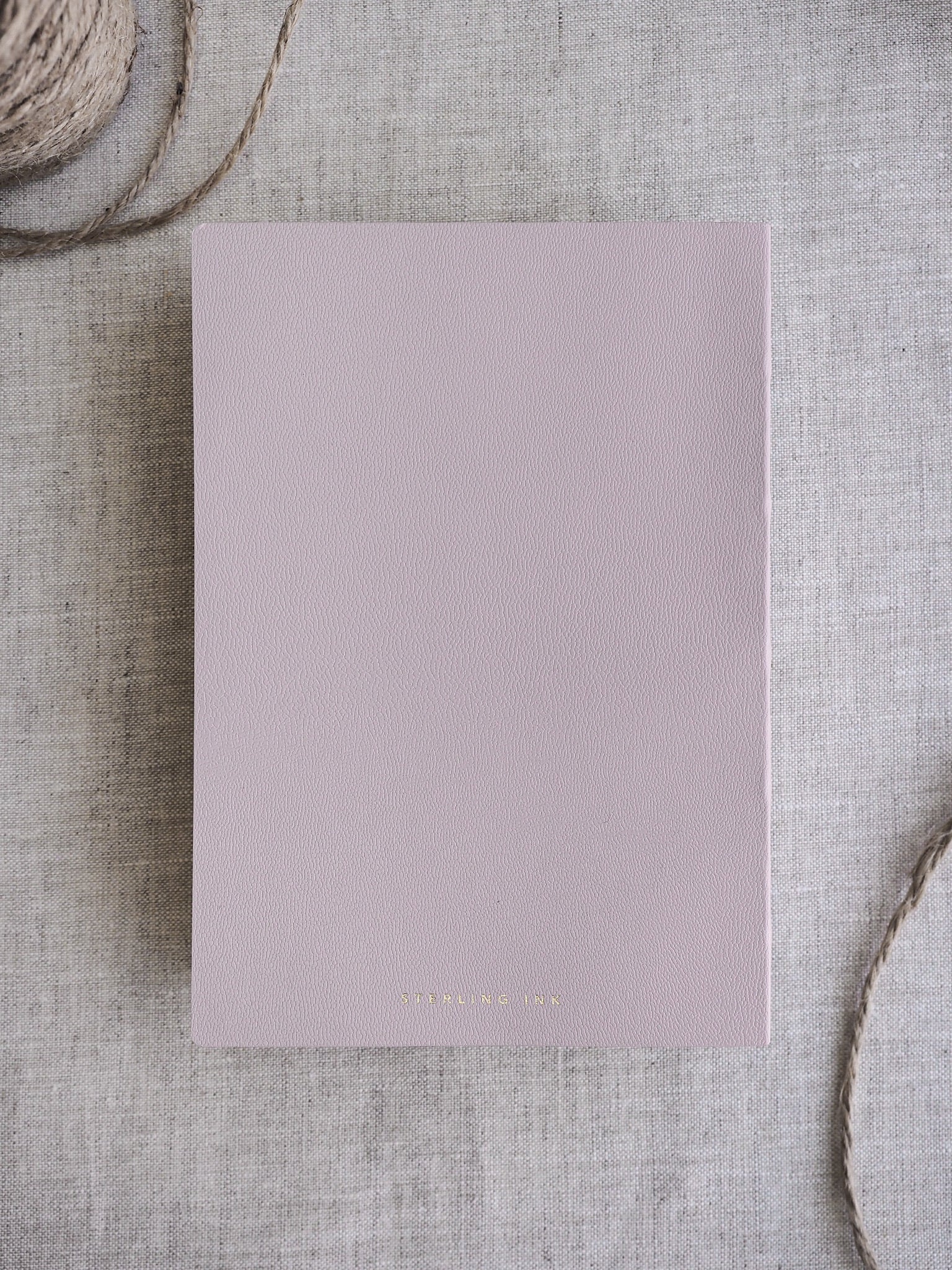 Solid, minimalist B6 grid notebook featuring a pale dusty rose cover, ideal for note-taking and journaling without page numbers.