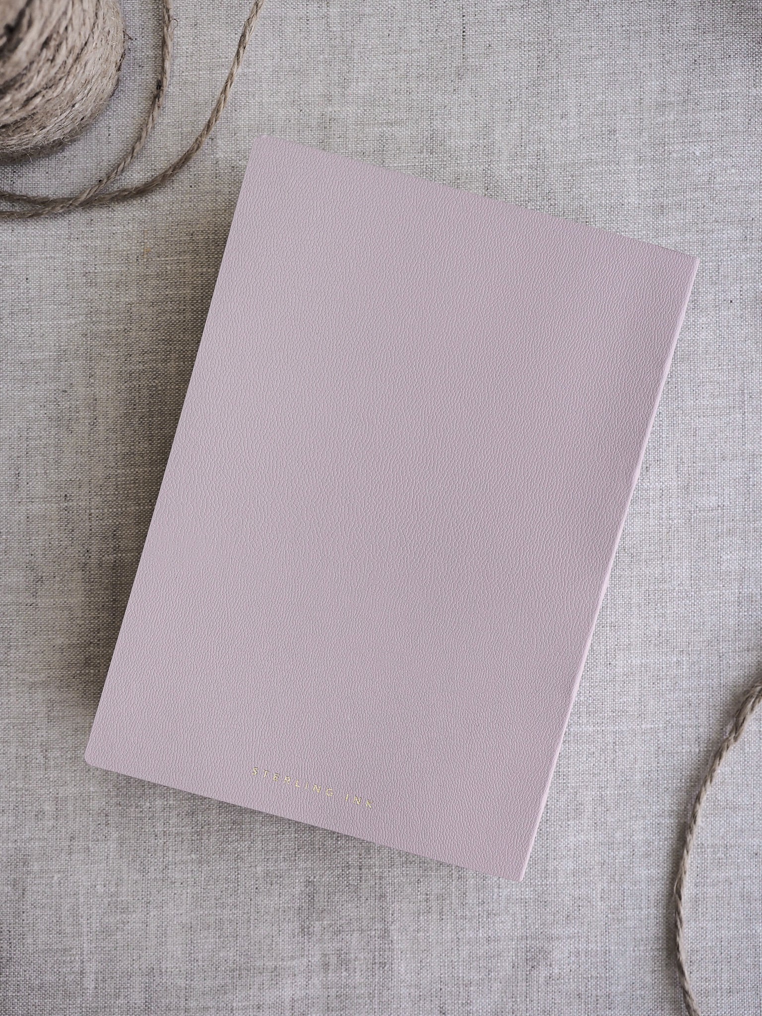 Dusty rose minimalist notebook featuring a smooth, matte cover, perfect for organized travel journaling and daily planning.