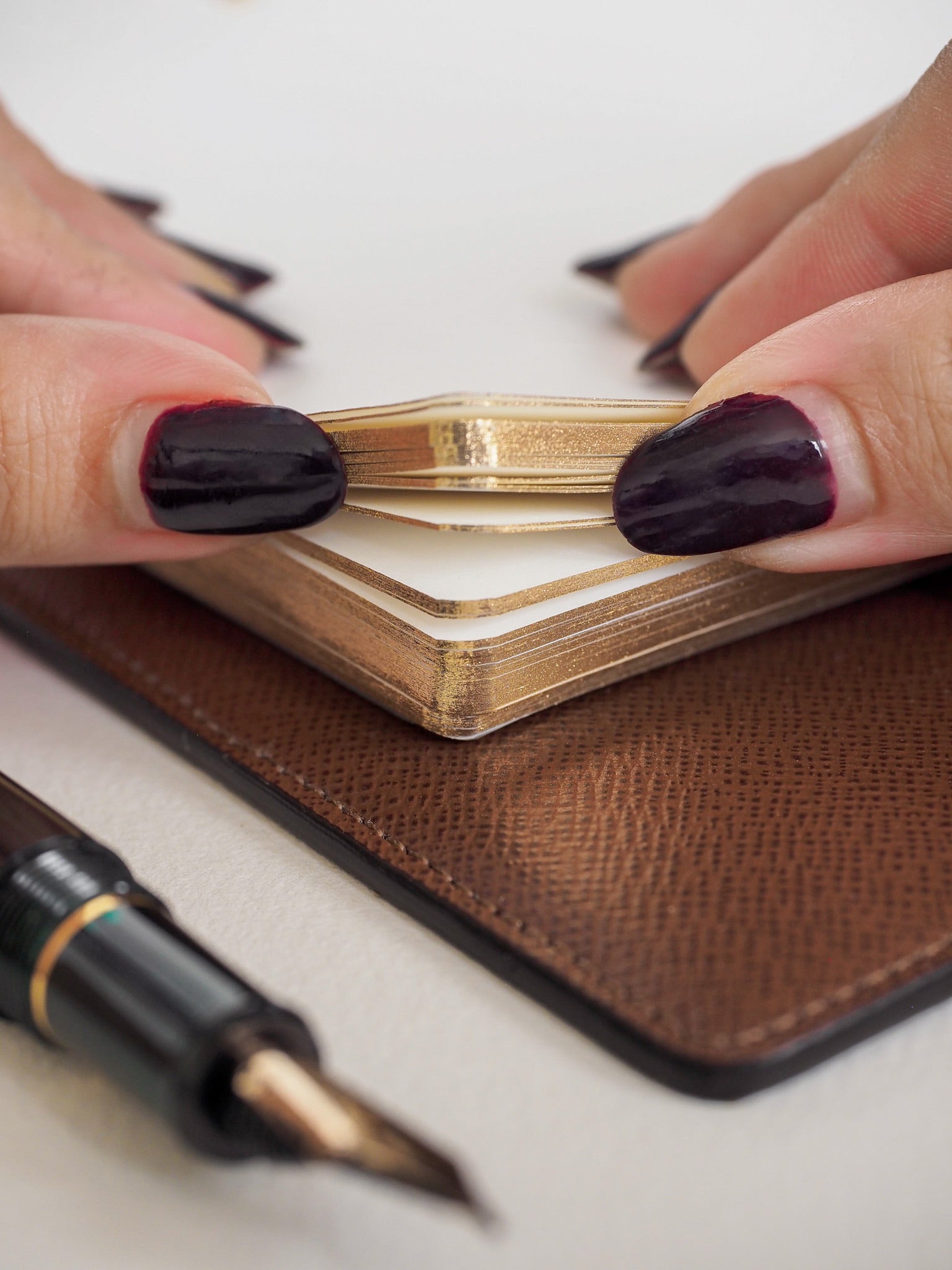 Stack of premium loose leaf paper with subtle lines and an elegant antique gold finish.