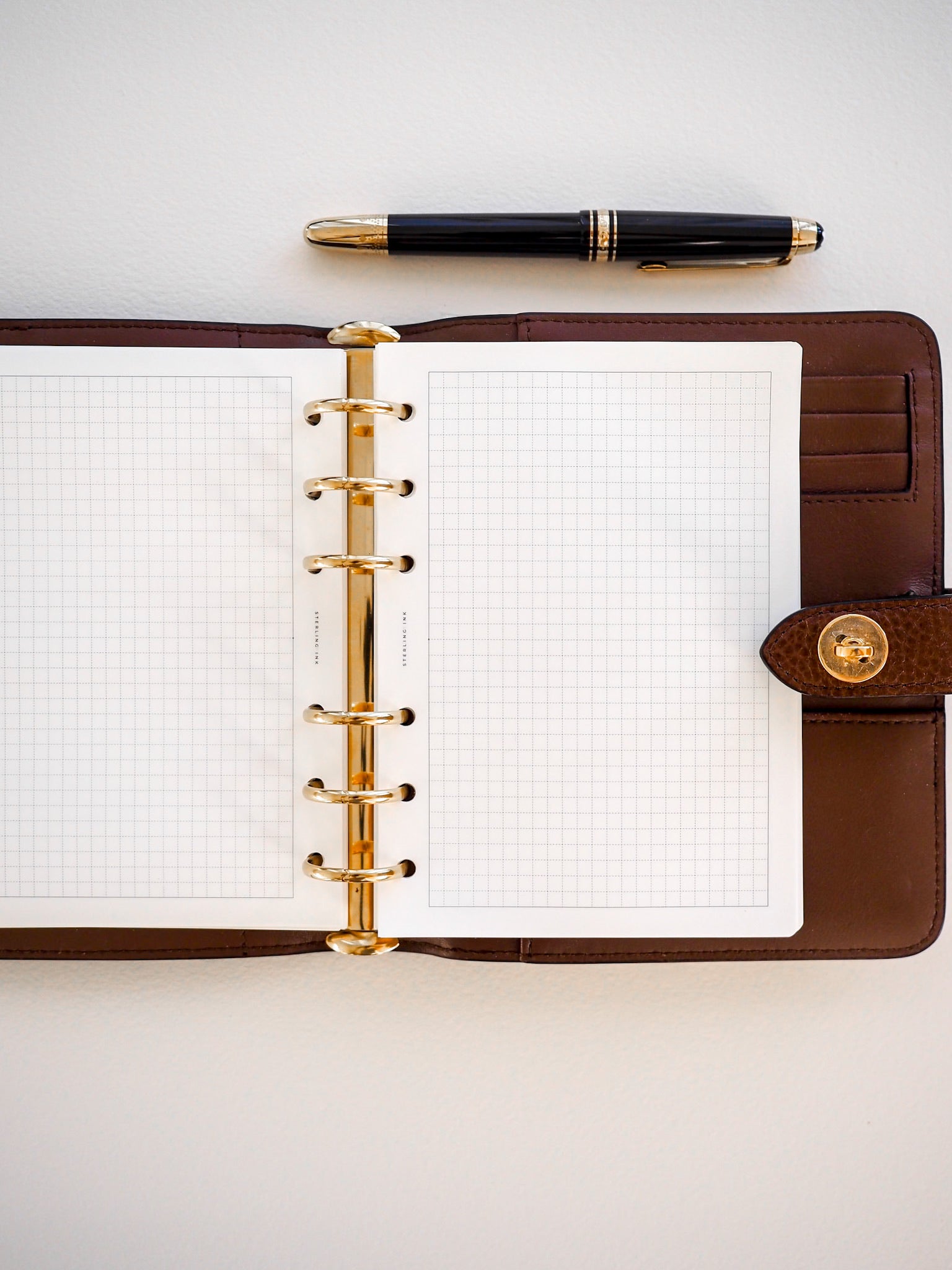Spiral-bound loose leaf notebook featuring crisp white Tomoe River paper printed with a precise, uniform grid pattern for detailed note-taking.