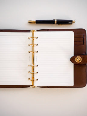 Spiral-bound pad featuring clean, white 5mm lines held within a rich brown faux-leather folio cover.