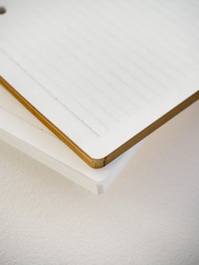 Pristine sheet of white Tomoe River paper featuring neatly printed 5mm horizontal lines and a warm, natural wooden edge.