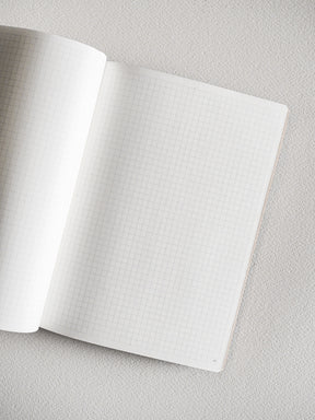 Open B6 grid notebook featuring structured, graph-patterned pages with light lines and printed page numbers, perfect for detailed planning and writing.