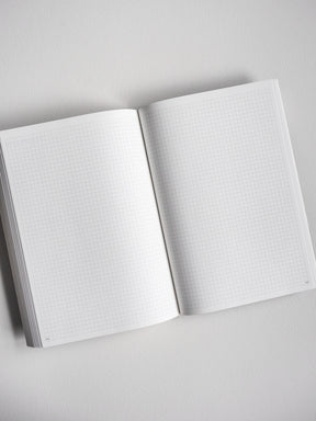 Open A5 undated daily planner featuring light, graph-style grid lines across two blank pages, ideal for journaling, note-taking, or detailed scheduling.