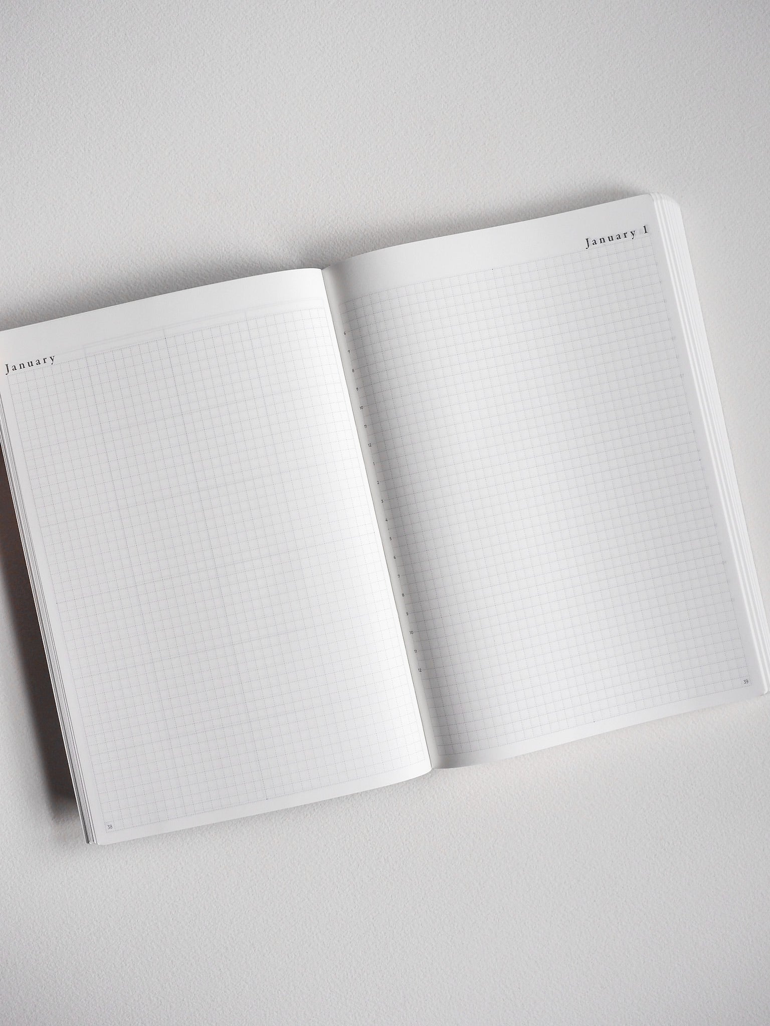 An open A5 undated planner showcasing light-grid graph paper pages perfect for daily journaling, note-taking, and scheduling.