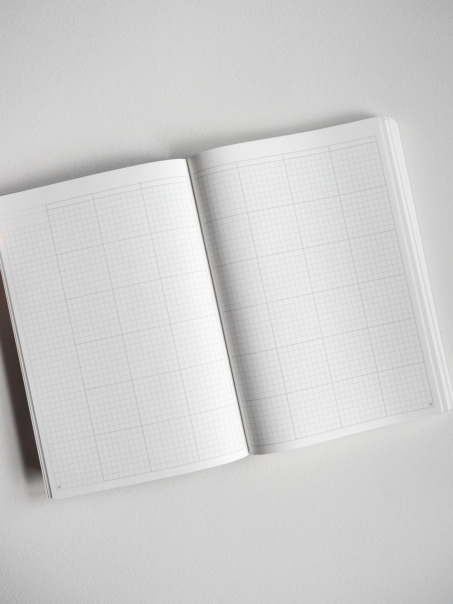 Open A5 undated planner book featuring two pages of neat, light grey grid graph paper for daily organization and journaling.