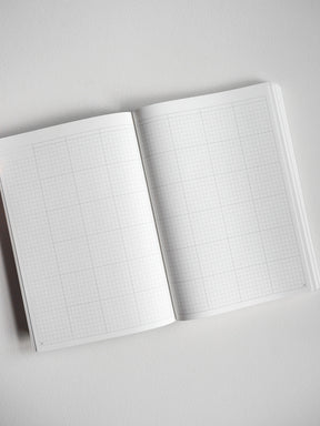 Open A5 undated planner book featuring two pages of neat, light grey grid graph paper for daily organization and journaling.