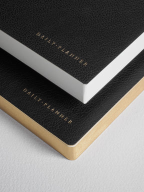 Black B6 daily planner set featuring matte covers and elegant gold foil lettering, ideal for planning an undated full year.