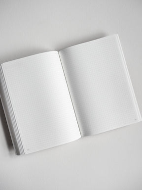 Open B6 undated daily planner featuring crisp, light-grid graph paper pages for flexible year-long planning and journaling.