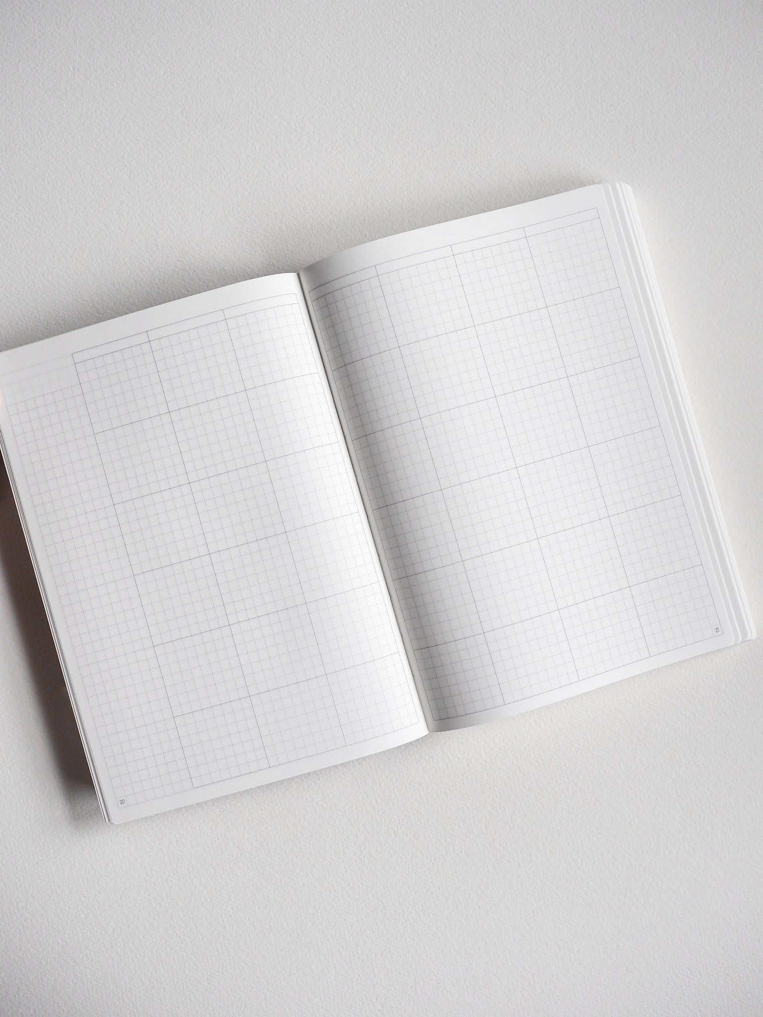 Open B6 undated daily planner displaying two gridded pages of light graph paper, perfect for detailed scheduling and year-long organization.