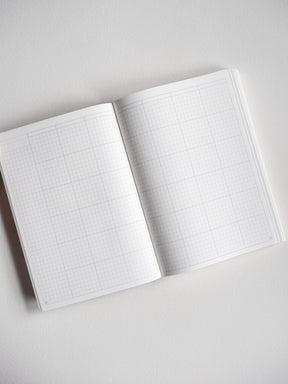 Open B6 undated daily planner displaying two gridded pages of light graph paper, perfect for detailed scheduling and year-long organization.