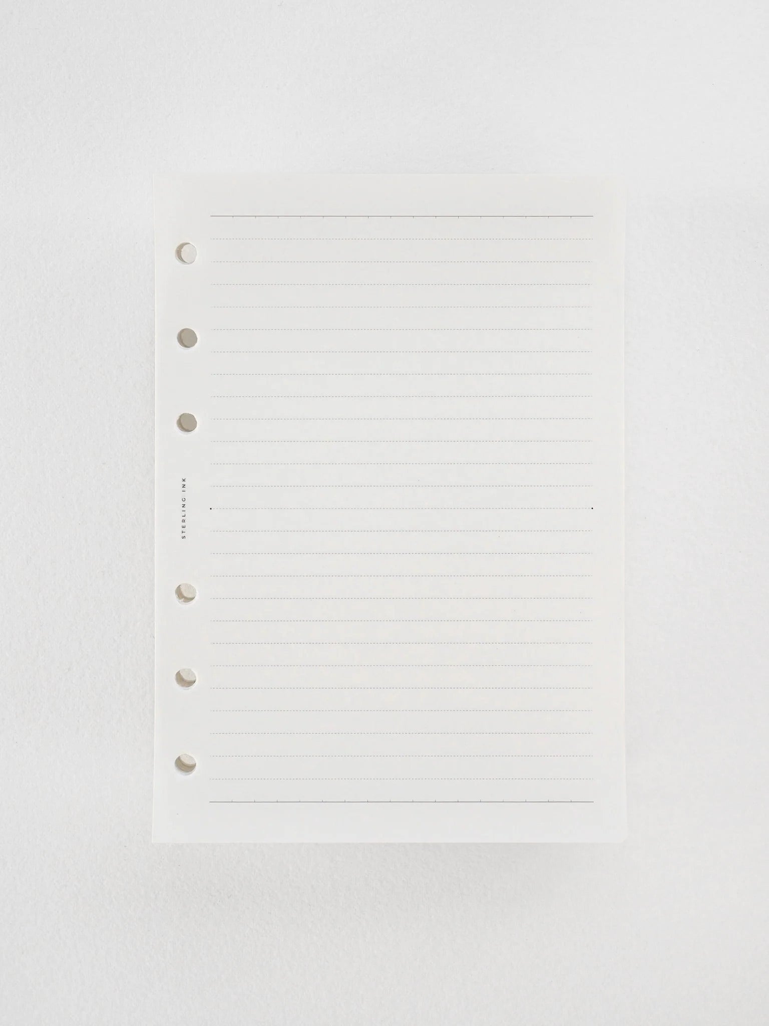A stack of premium Tomoe River brand loose leaf paper, featuring white sheets precisely ruled with 5mm horizontal blue lines for writing and journaling.