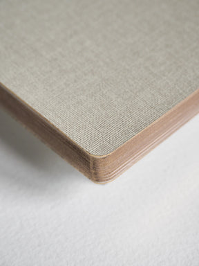 Close-up of a square panel corner showing a woven or textured light beige top surface with layered natural wood edges, photographed on a white background.
#Color_Linen