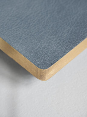 Close-up of a square product corner showing a textured slate blue top surface and a natural light wood edge, photographed on a light gray background.
#Color_Mist