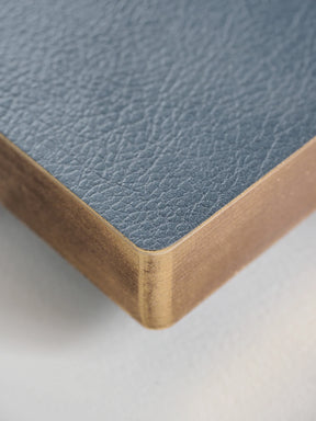 Close-up of a notebook corner showing a light blue textured cover and white page edges on a white background.
#Color_Mist