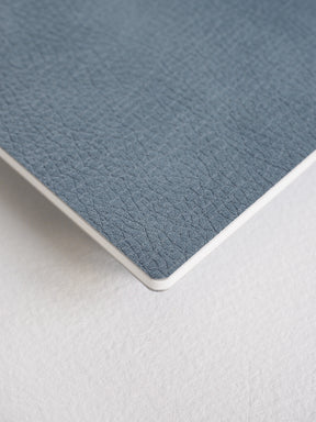 Durable charcoal gray booklet featuring a fine, pebbled faux leather texture, designed as a compact notebook for travel and correspondence.