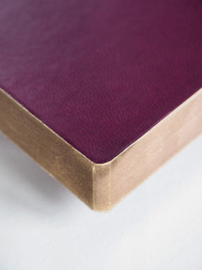 Elegant A5 planner featuring a solid deep purple cover and luxurious metallic gold edges for full year planning.