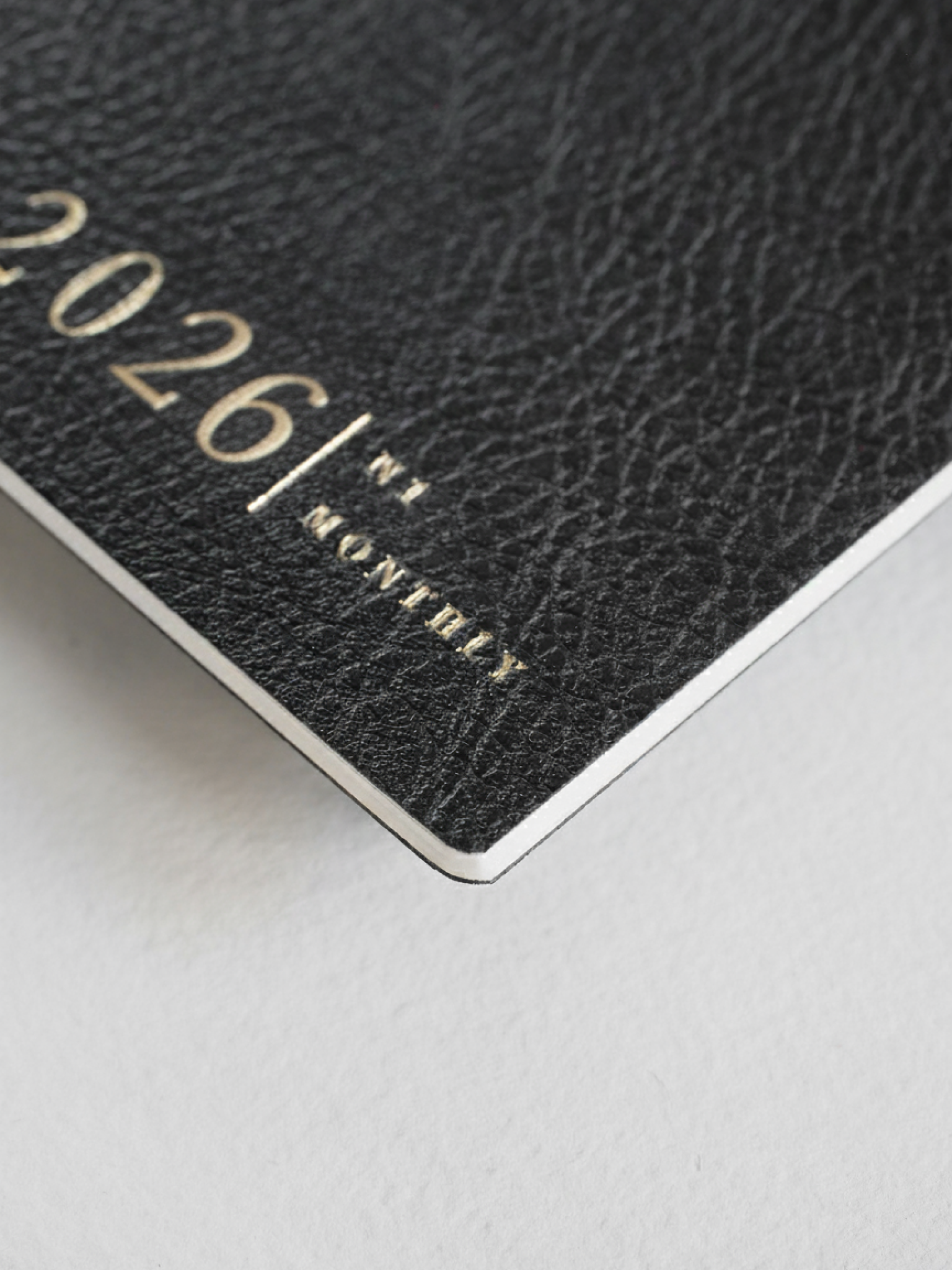 Dark, textured N1 monthly booklet cover with elegant embossed branding reading "2026," perfect for a yearly planner or journal.
