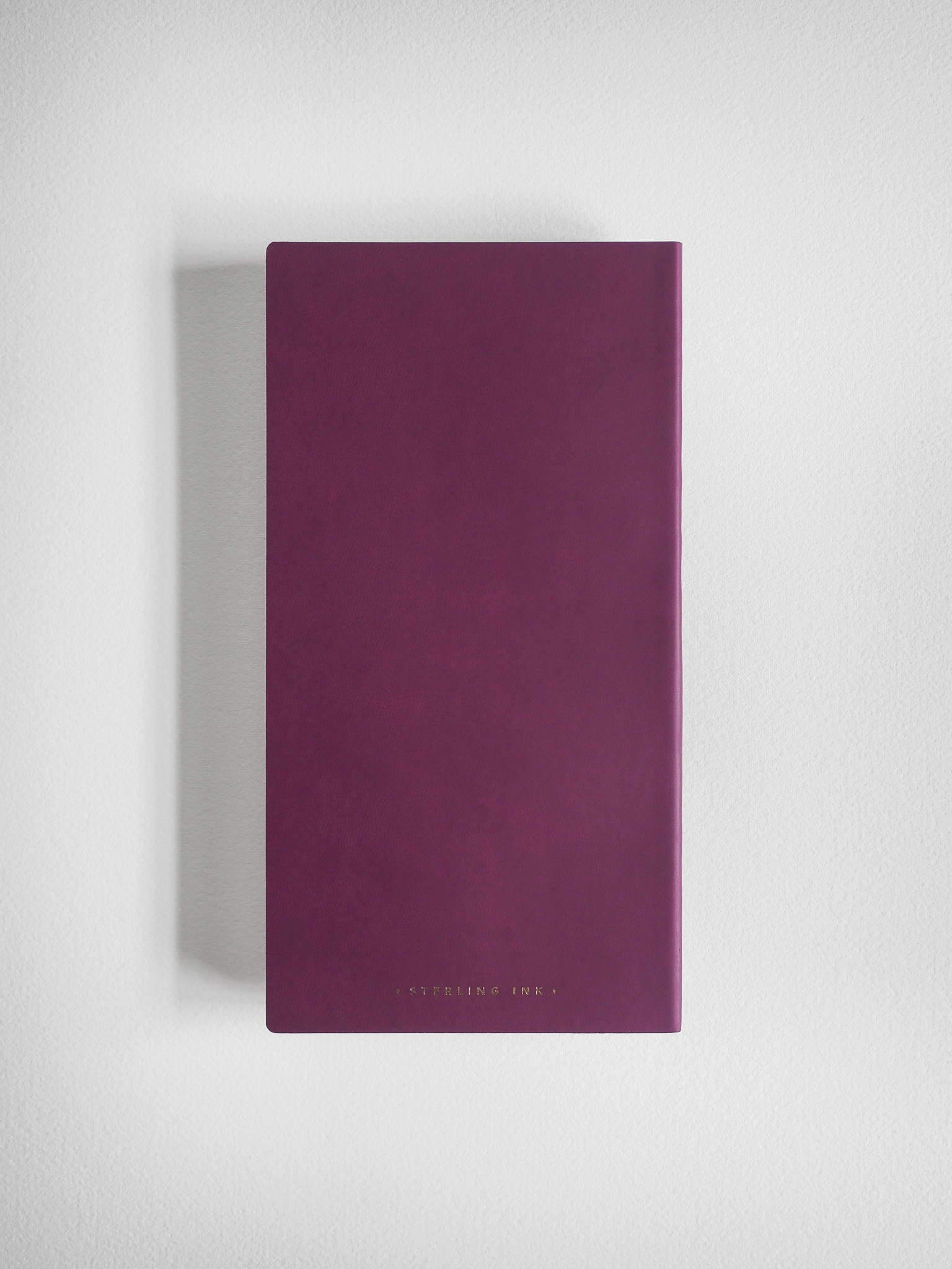 A solid, deep magenta notebook from Sterling Ink, featuring a simple cover with a subtle, centered brand logo.