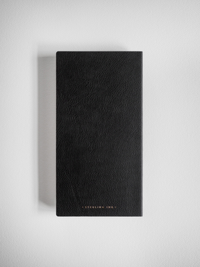 Elegant black grid notebook with a deeply textured, minimalist faux leather cover, ideal for journaling or studying.