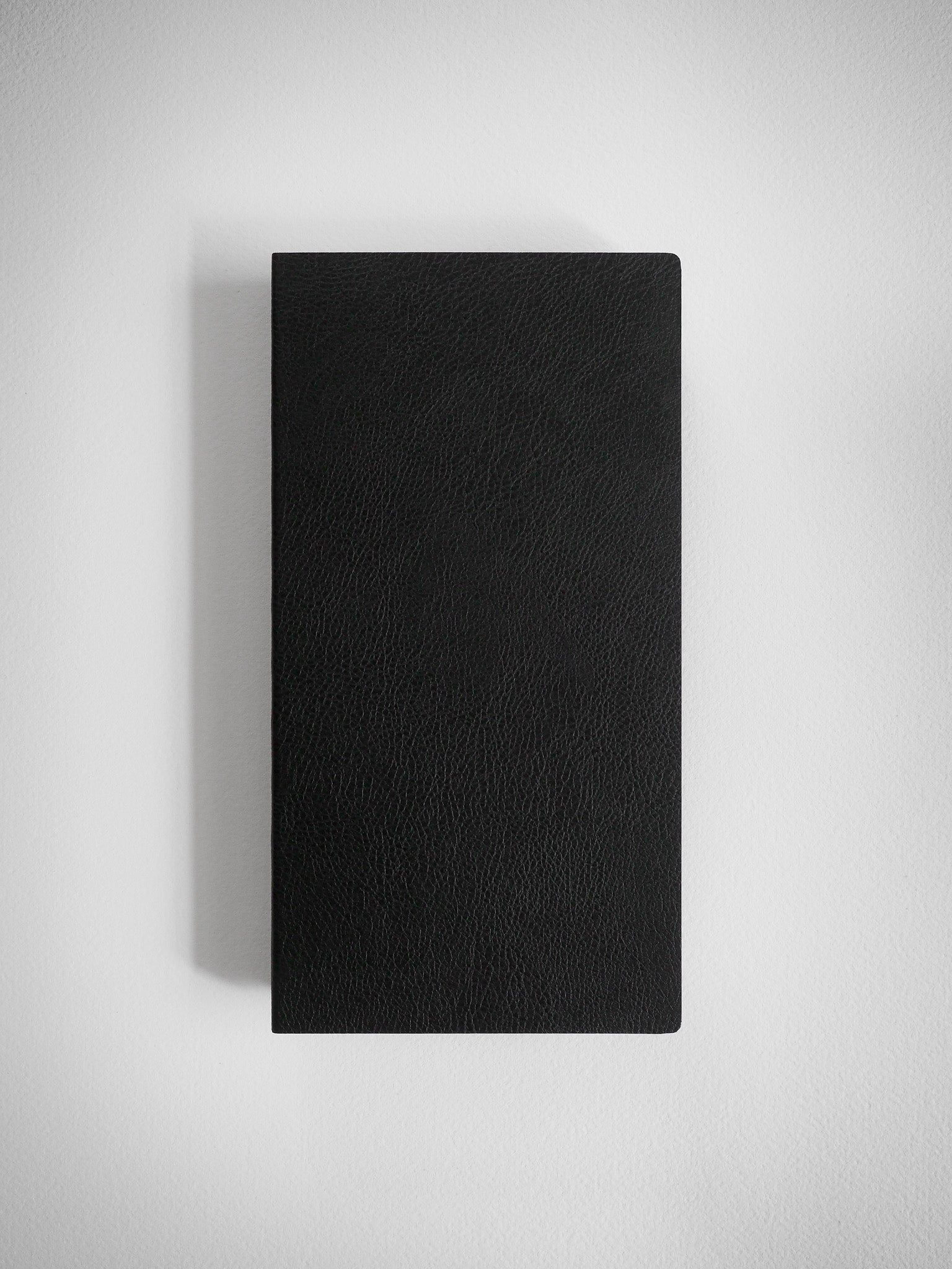 A sophisticated, matte black notebook featuring a uniform, subtly textured cover suitable for writing and journaling.