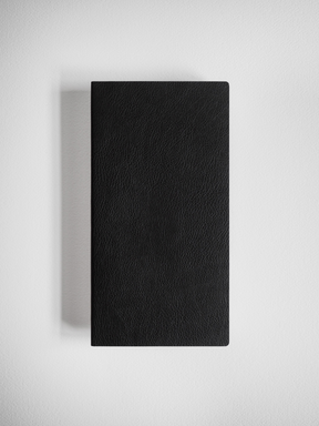 Minimalist black grid notebook featuring a sleek, solid cover with a fine, textured grain that suggests durable faux leather binding.