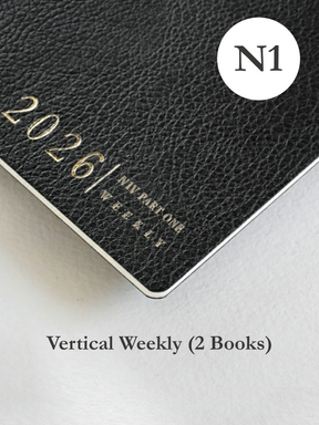 Sophisticated dark material weekly planner cover featuring elegant gold foil stamping of the years 2026 and the title "NIV PART ONE WEEKLY."