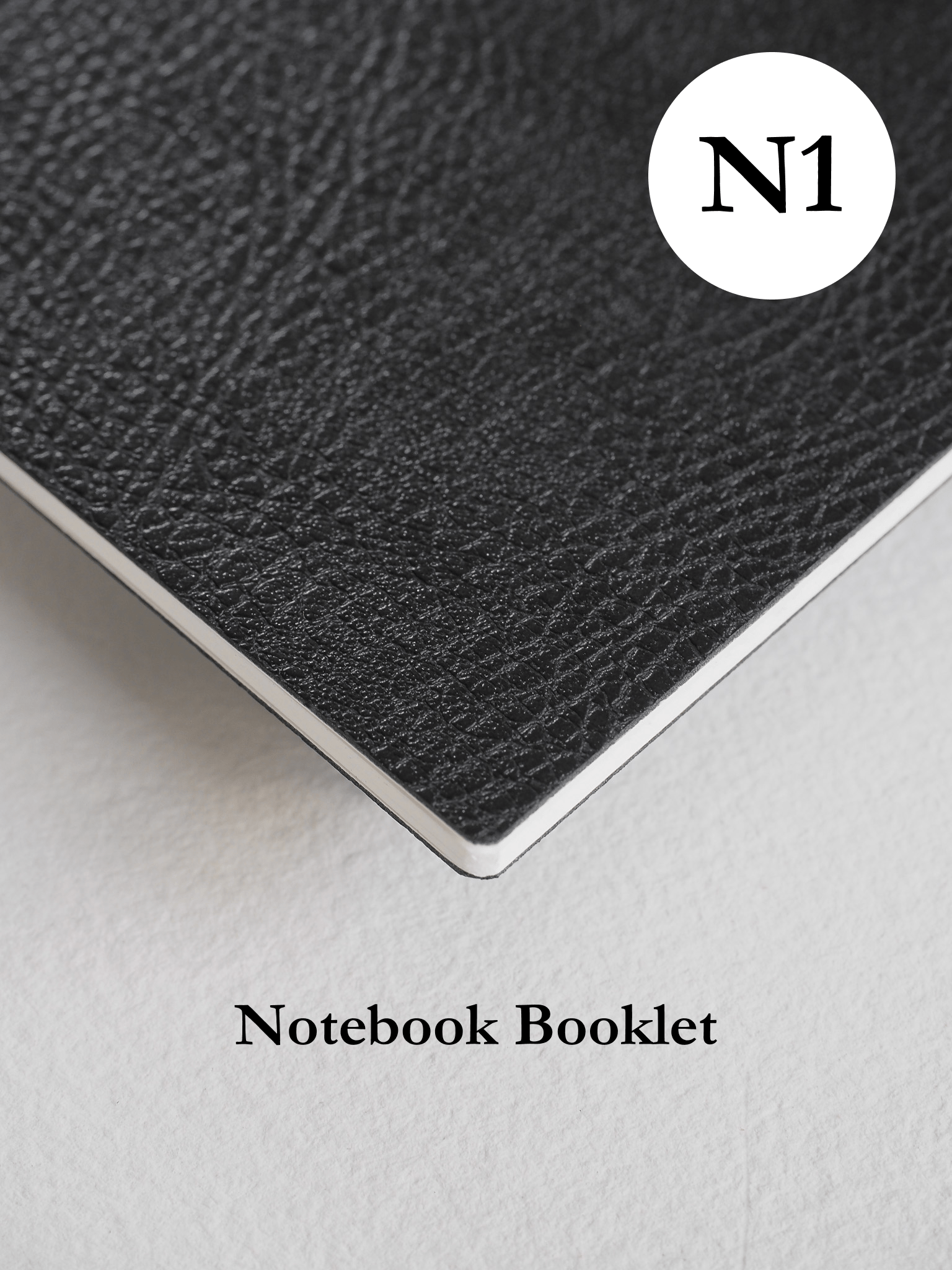 Dark gray, textured notebook booklet with a matte finish, featuring a clean, circular white logo element bearing the brand name N1.