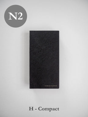 Textured black faux leather planner cover featuring a rich pebbled grain finish and subtly embossed "COMMON PLANNER" branding.