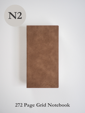 Minimalist brown notebook featuring a textured, matte faux leather cover, designed for 272 pages of gridded writing and planning.