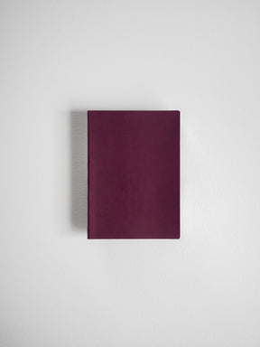 Minimalist deep burgundy notebook with a smooth, solid cover, ideal for grid note-taking, journaling, or travel documentation.