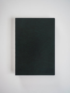 Matte black A5 grid notebook featuring a textured, sophisticated faux leather cover, perfect for detailed planning and writing.