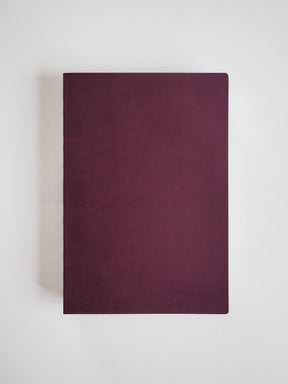 Plain A5 notebook with a smooth, matte, deep burgundy faux leather cover, perfect for journaling or structured note-taking.