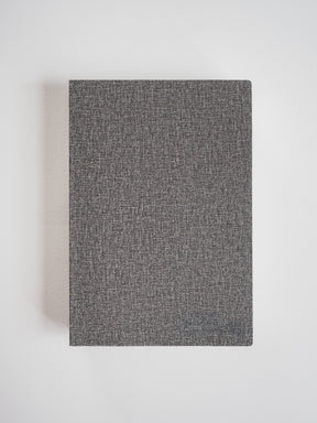 Sophisticated A5 notebook featuring a dark charcoal gray cover with a subtle, finely textured, heathered fabric finish.