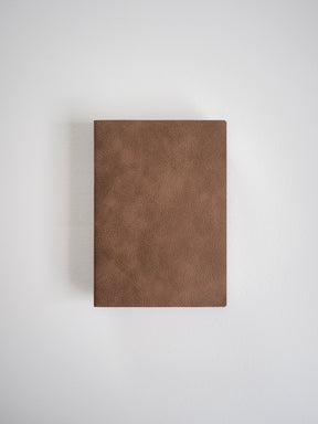 Solid, rectangular A6 notebook with a smooth, matte brown faux leather cover, designed for journaling or academic grids.