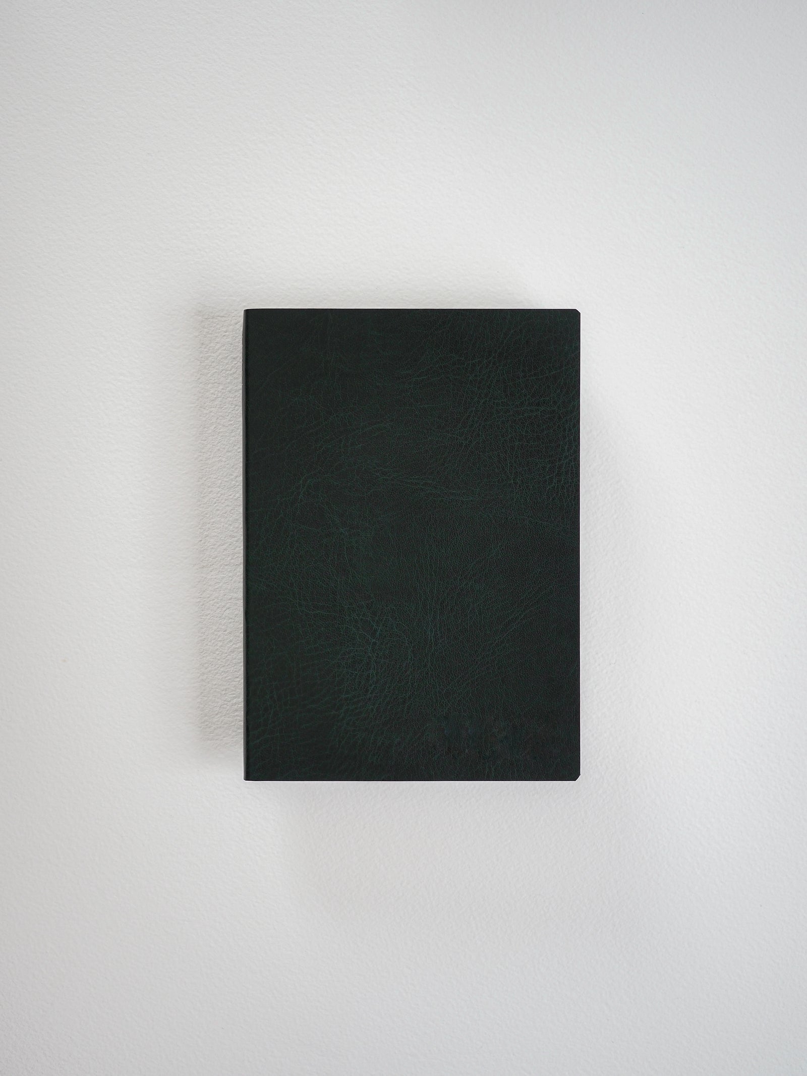 Matte black A6 grid notebook featuring a textured, dark faux-leather cover, ideal for detailed journaling, planning, or structured writing.
