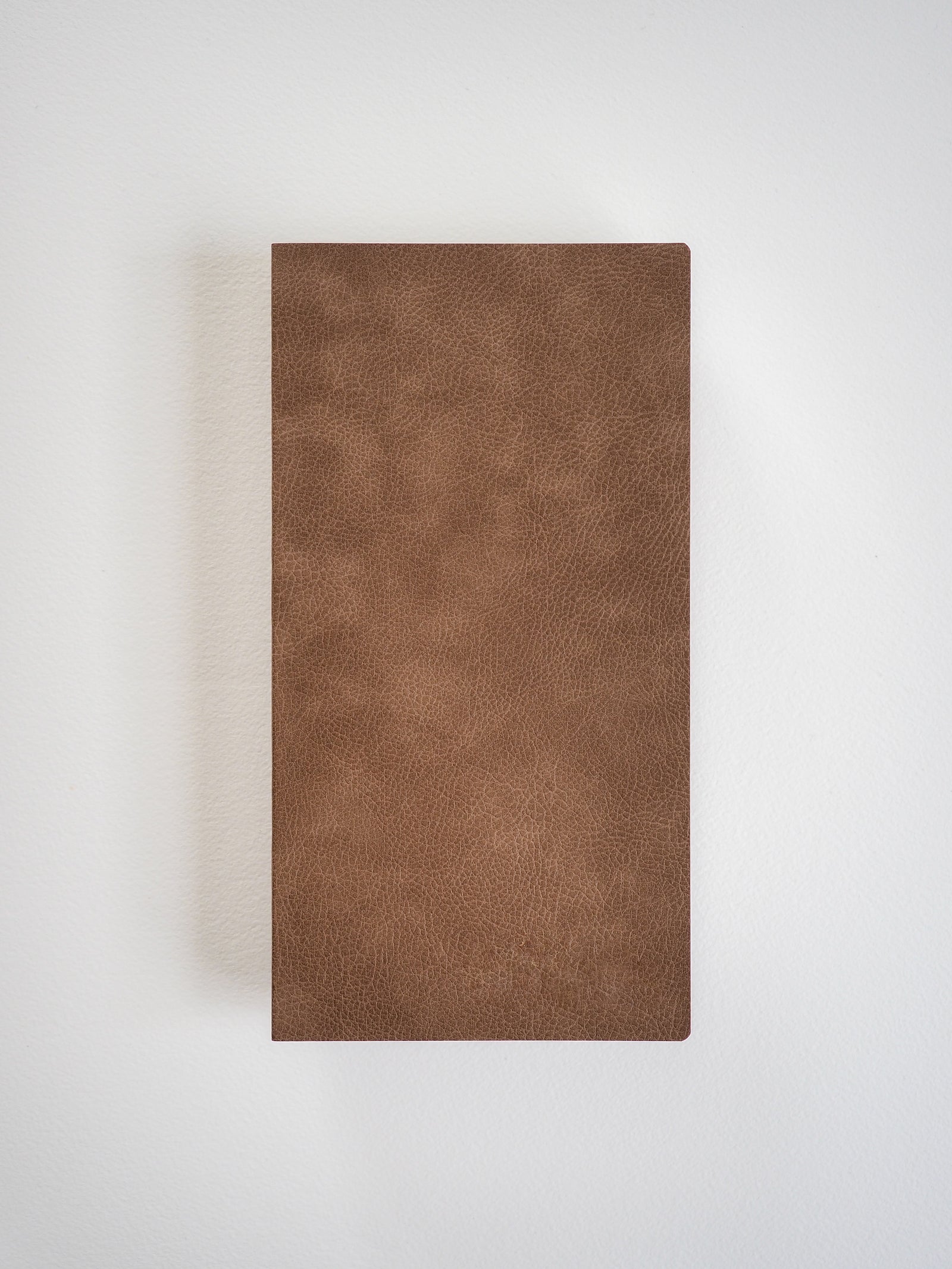 A minimalist, deep mocha brown notebook featuring a textured, sleek faux leather cover for writing and journaling.