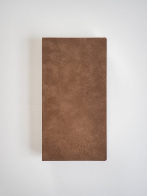 A minimalist, deep mocha brown notebook featuring a textured, sleek faux leather cover for writing and journaling.