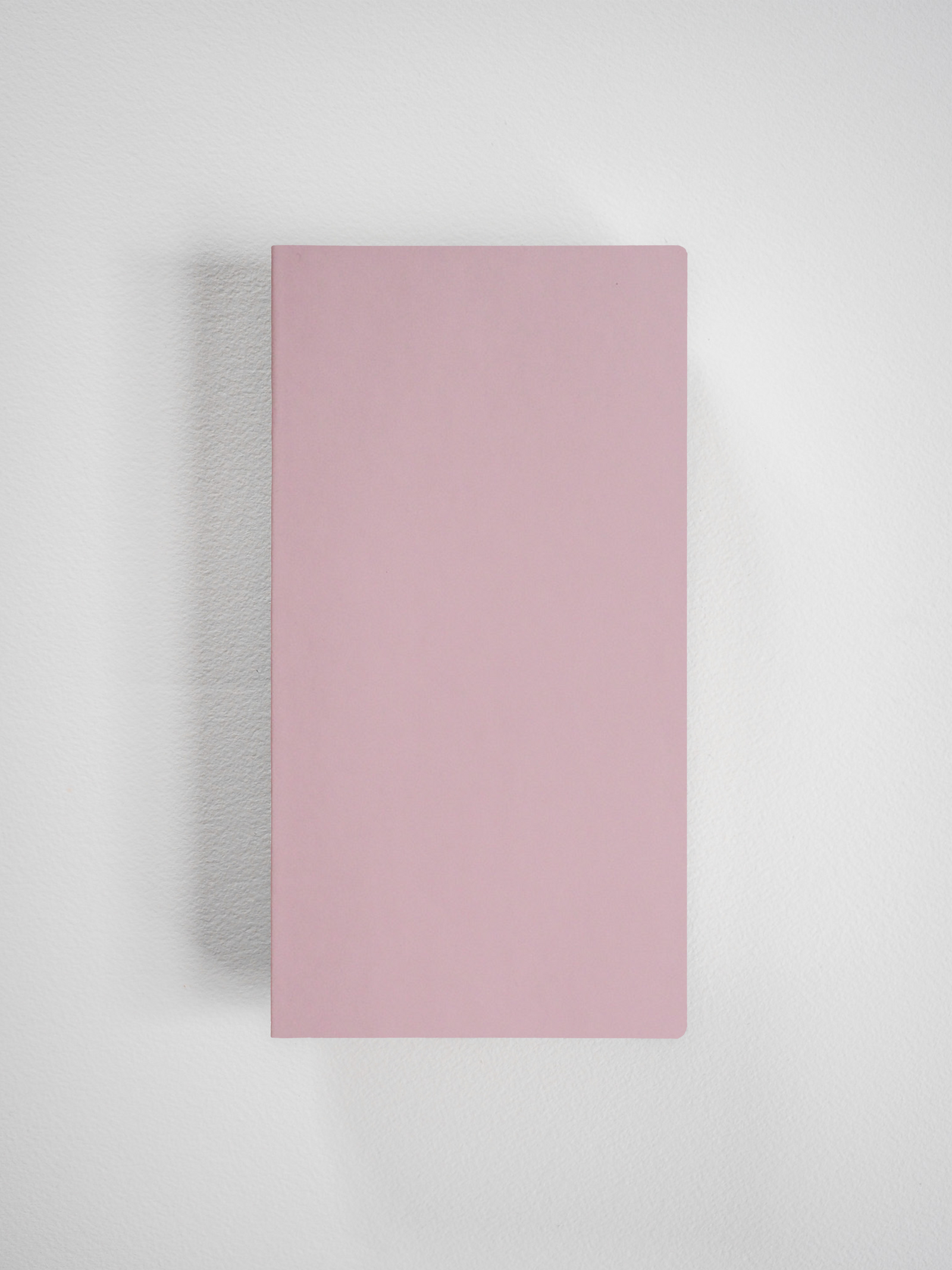 Solid rectangular grid notebook cover in a minimalist, solid pale pink hue.
