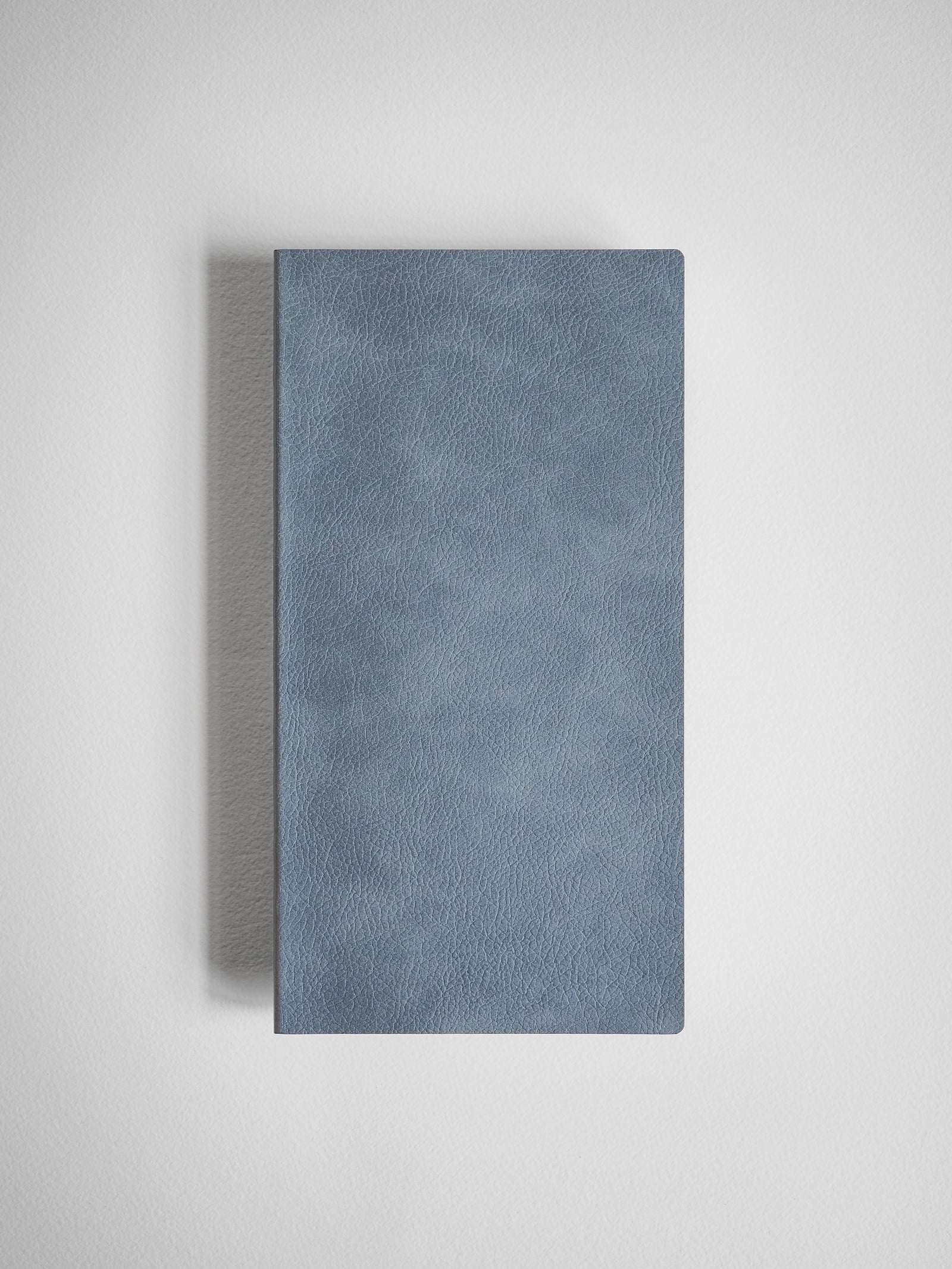Solid slate blue grid notebook featuring a minimalist, smooth faux leather cover ideal for journaling and structured note-taking.