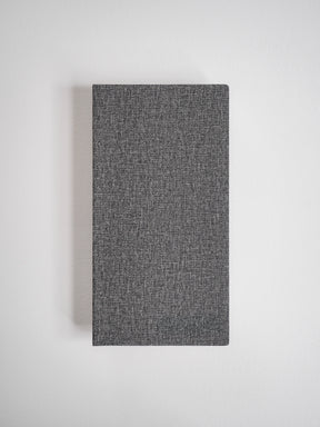 Textured charcoal gray grid notebook with a minimalist, woven cover, suitable for journaling and planning.