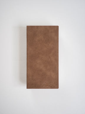 Solid, rectangular grid notebook bound with a rich, uniform brown cover that features a subtly textured, faux leather finish.